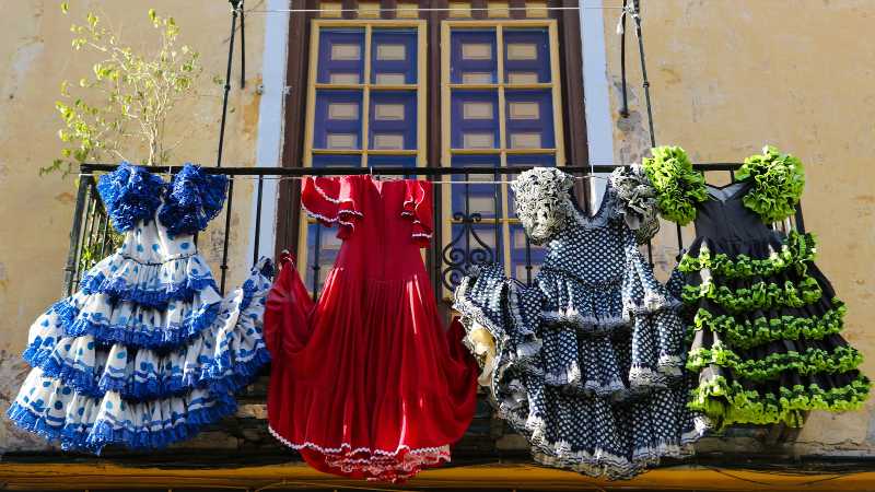 Fire fargerike tradisjonelle flamenco kjoler henger fra en balkong